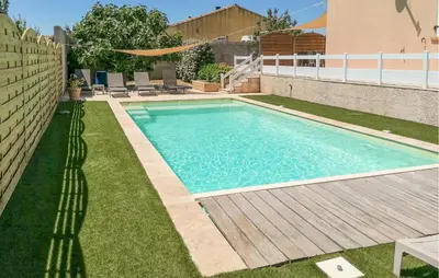 a swimming pool in a yard with a wooden deck at Stunning Home In Saint-Nazaire-D'aude in Saint-Nazaire-dʼAude