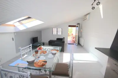 a kitchen and living room with a glass table at Gîte les Lauriers des orgues d'Ille - la Sybille in Ille-sur-Têt