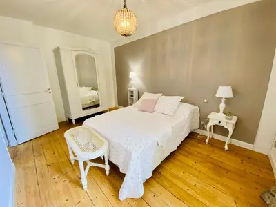 a bedroom with a bed and two tables and a mirror at Gite des Platanes in Belvèze-du-Razès