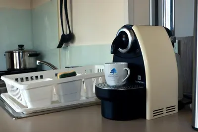 a coffee maker sitting on a counter with a cup at Mobilhome Côté mer - 3 Chambres - Climatisé - TV in Sigean