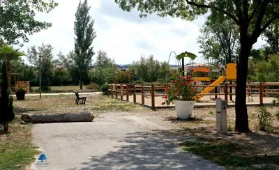 a park with a playground with a slide at Mobilhome Côté mer - 3 Chambres - Climatisé - TV in Sigean