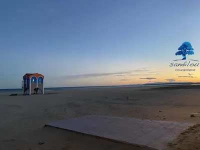 a small shack on the beach at sunset at Mobilhome Côté mer - 3 Chambres - Climatisé - TV in Sigean