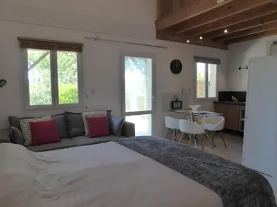 a bedroom with a large bed and a couch at La Maison Barthélemy: Voie Verte et piscine in Bellegarde-du-Razès