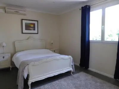 a bedroom with a white bed and a window at La Maison Barthélemy: Voie Verte et piscine in Bellegarde-du-Razès