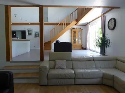 a living room with a couch and a staircase at La Maison Barthélemy: Voie Verte et piscine in Bellegarde-du-Razès