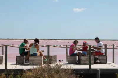 a group of people sitting on a dock near the water at La Souqueto in Mirepeisset