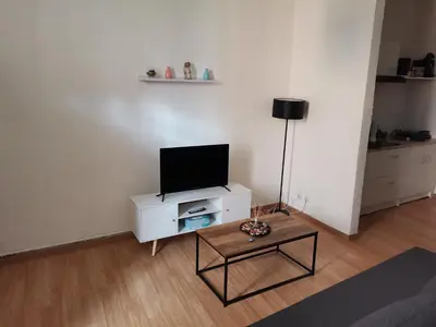 a living room with a tv on a white cabinet at Studio au cœur du quartier historique in Narbonne