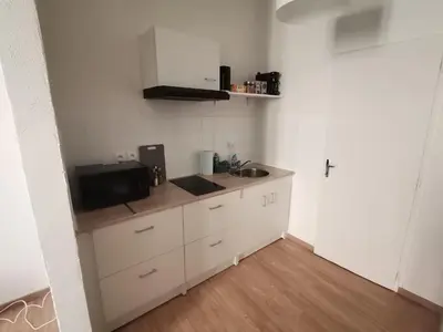 a small kitchen with white cabinets and a sink at Studio au cœur du quartier historique in Narbonne