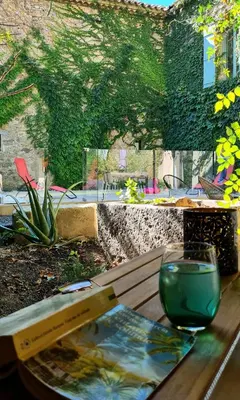 a wooden table with a glass on top of it at Appartements cocons dans les Corbières in Villesèque-des-Corbières