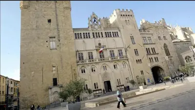 a large stone building with a clock tower at Le Belfort 1 Studio lumineux quartier historique les halles in Narbonne