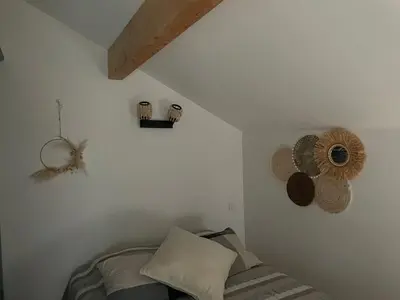 a bedroom with white walls and a bed and a ceiling at La Bergerie in Saint-Vincent