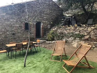 a table and chairs in front of a stone building at La Bergerie in Saint-Vincent