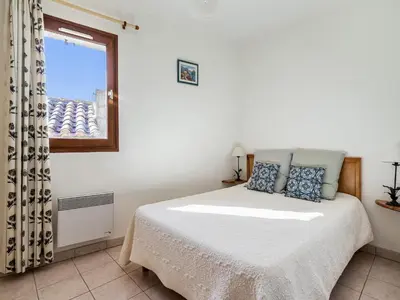 a white bedroom with a bed and a window at Vineyards & Village Stay in Minerve