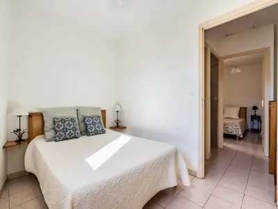 a bedroom with a white bed with blue pillows at Vineyards & Village Stay in Minerve