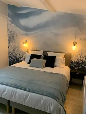 a bedroom with a large bed with a painting on the wall at Dans ma Bulle - Les Balcons de la Cité in Carcassonne