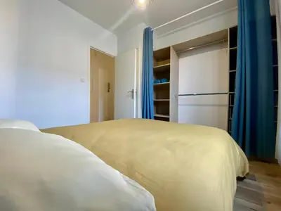 a bedroom with a white bed and a refrigerator at Zen appart - 35m2 à Carcassonne in Carcassonne