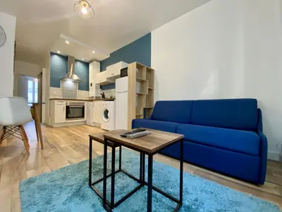a living room with a blue couch and a table at Zen appart - 35m2 à Carcassonne in Carcassonne