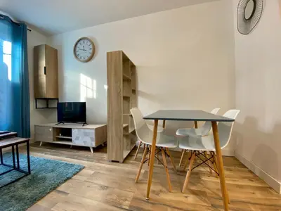 a dining room with a table and white chairs at Zen appart - 35m2 à Carcassonne in Carcassonne