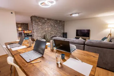 a living room with three laptops on a wooden table at L'écrin de la Cité, Grand Panorama, vue unique sur les remparts de Carcassonne in Carcassonne