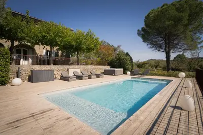 a swimming pool with lounge chairs next to a house at L'écrin de la Cité, Grand Panorama, vue unique sur les remparts de Carcassonne in Carcassonne