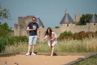a man and a woman standing in front of a castle at L'écrin de la Cité, Grand Panorama, vue unique sur les remparts de Carcassonne in Carcassonne