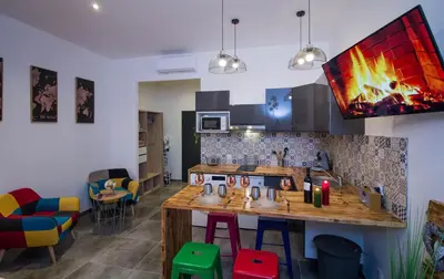 a kitchen with a bar with colorful stools at Au Canal du Midi - Appartements au cœur de la ville in Carcassonne