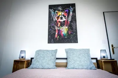 a painting of a dog on the wall above a bed at Au Canal du Midi - Appartements au cœur de la ville in Carcassonne