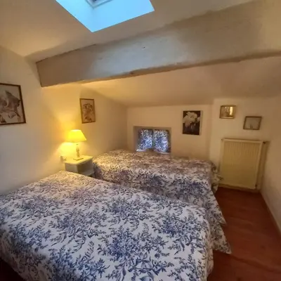 a bedroom with two beds and a skylight at L'OCCITANE appartement climatisé centre ville in Limoux