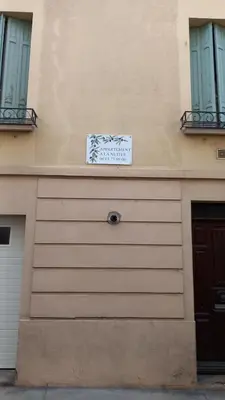 a sign on the side of a building with a garage at L'OCCITANE appartement climatisé centre ville in Limoux