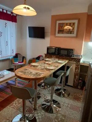 a room with a table with chairs and a television at L'OCCITANE appartement climatisé centre ville in Limoux