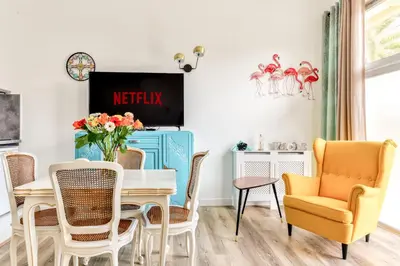 a dining room with a table and chairs and a tv at Loft Plage du Grazel in Gruissan