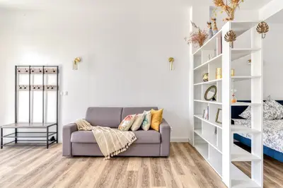 a living room with a couch and shelves at Loft Plage du Grazel in Gruissan