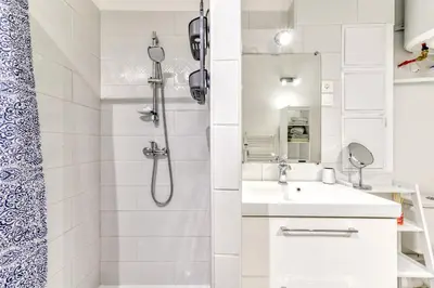a white bathroom with a shower and a sink at Loft Plage du Grazel in Gruissan