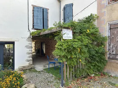 a house with a sign on the side of it at Gîte La Glycine in Dun