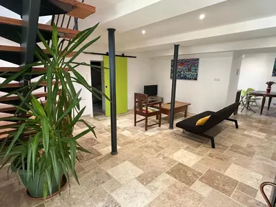 a living room with a chair and a plant at Gîte La Glycine in Dun