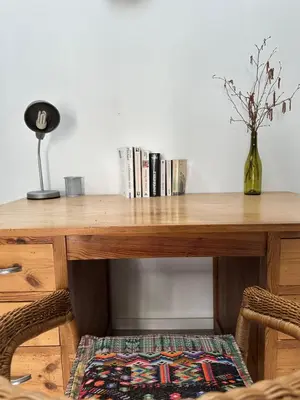 a wooden table with a vase on top of it at Gîte La Glycine in Dun