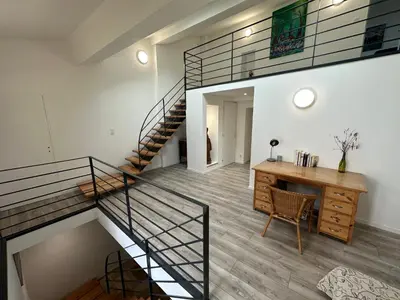 a staircase in a home with a desk and a stair case at Gîte La Glycine in Dun