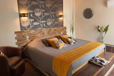 a bedroom with a bed and a couch and a wall at LE PETIT CLOS in Fontjoncouse