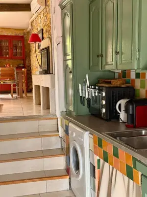 a kitchen with green cabinets and a washing machine at LE PETIT CLOS in Fontjoncouse