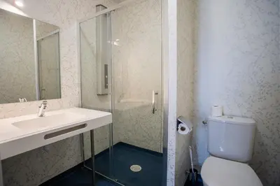 a bathroom with a toilet and a sink and a shower at CIS Lamourelle Centre International de Sejour in Carcassonne