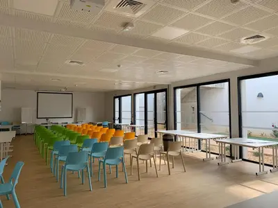 a classroom with colorful chairs and tables and a screen at CIS Lamourelle Centre International de Sejour in Carcassonne