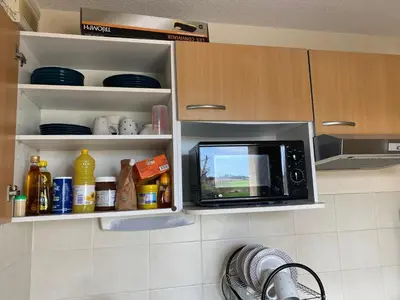 a microwave oven in a kitchen with some food at Best cocooning au calme avec parking privé in Carcassonne