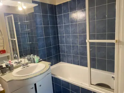 a blue tiled bathroom with a tub and a sink at Best cocooning au calme avec parking privé in Carcassonne