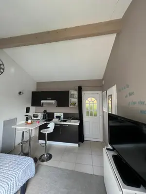 a kitchen with black cabinets and a table in a room at Studio RIQUET indépendant attenant à Villa in Capestang
