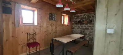 a table and chairs in a room with a stone wall at Villa Misanid écrin de verdure à 15mm de la cité de Carcassonne in Mas-des-Cours