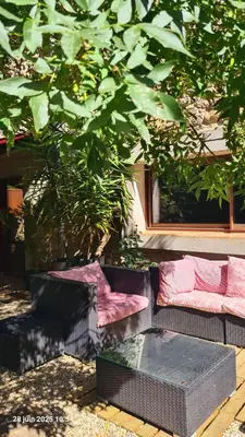 a group of couches sitting under a tree at Villa Misanid écrin de verdure à 15mm de la cité de Carcassonne in Mas-des-Cours