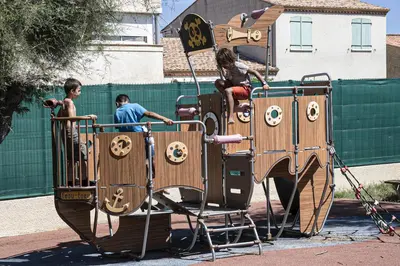 a group of children playing on a playground at Mobil Home XXL 4 chambres - Camping Le Barberousse in Gruissan