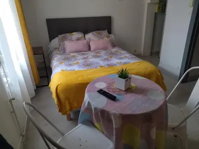 a bedroom with a bed with a table and chairs at Studio mirabeau les halles 15m2 climatisation in Narbonne