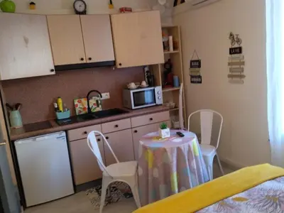 a small kitchen with a table and a microwave at Studio mirabeau les halles 15m2 climatisation in Narbonne