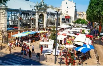 a group of people walking around a market with umbrellas at Studio mirabeau les halles 15m2 climatisation in Narbonne